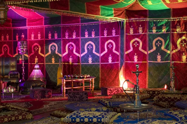 Kleurrijke tentdoeken, lampen, tapijten en lage zitkussens in een Arabische lounge